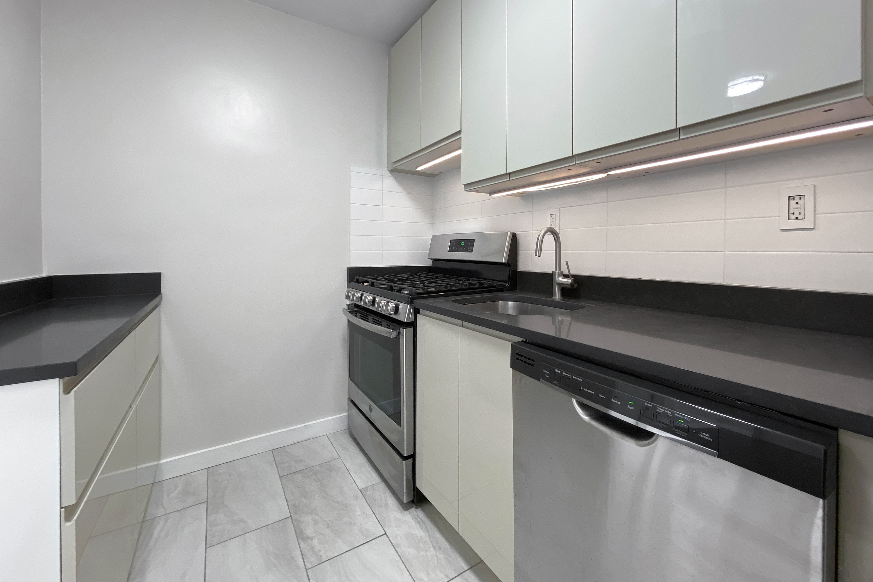 330 East 33rd Street, Unit 3F Manhattan, NY 10016 - Photo 5 of 15 a kitchen with granite countertop a sink and a stove