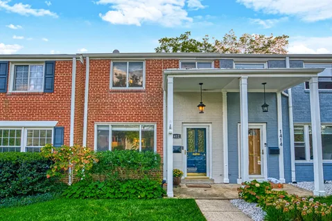 front view of a brick house with a small yard