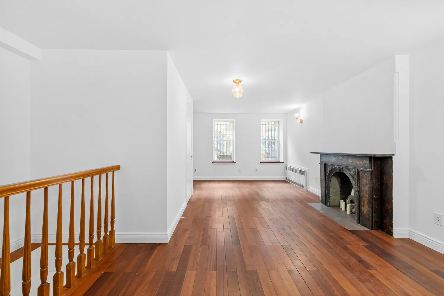 a view of a hallway with wooden floor and a fireplace