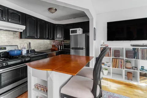 a kitchen with stainless steel appliances a stove a microwave a refrigerator and cabinets