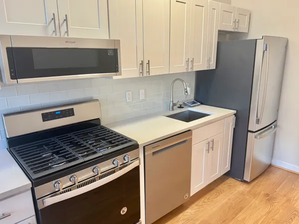 a kitchen with stainless steel appliances granite countertop a stove a refrigerator and a microwave