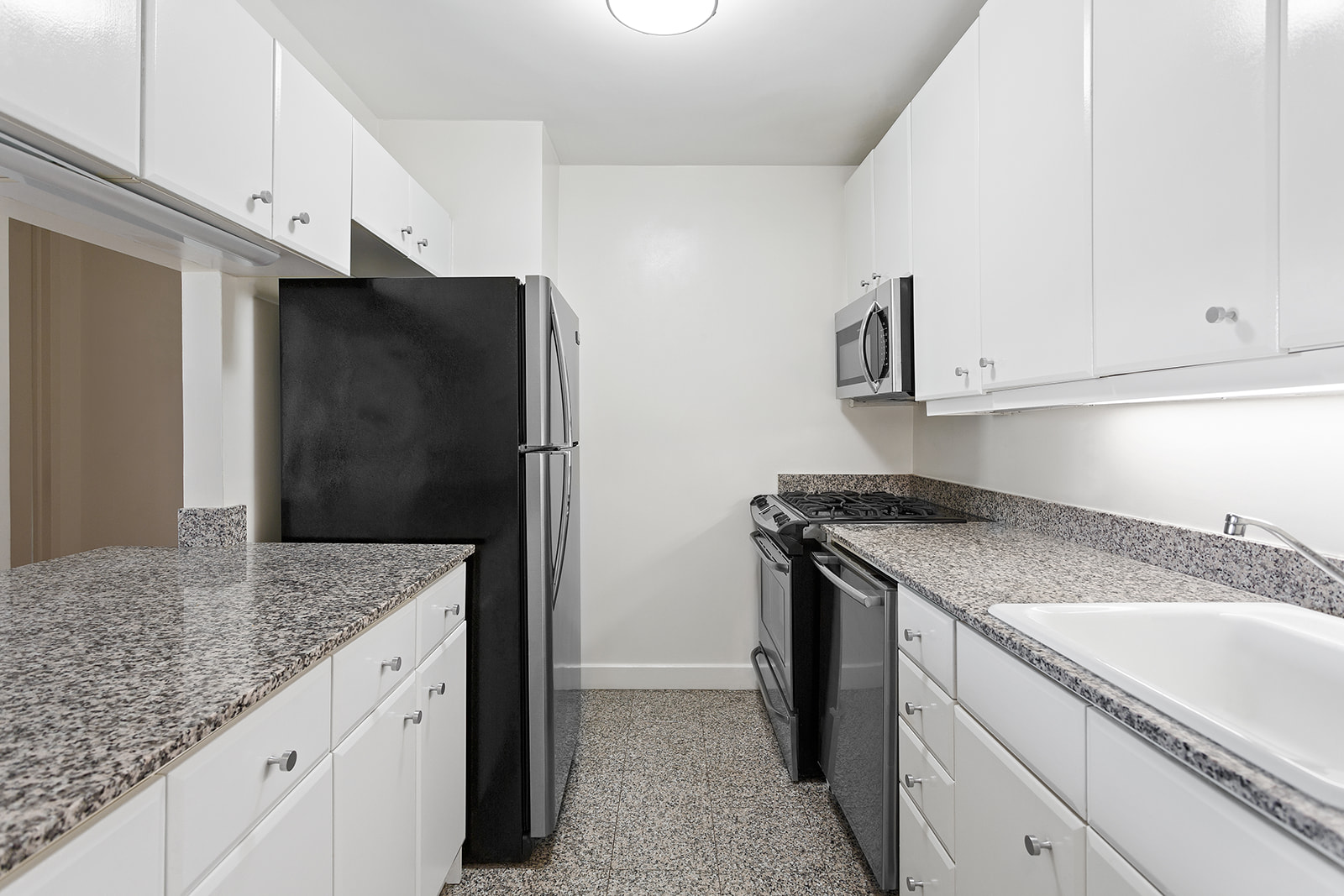 1965 Broadway, Unit 11D Manhattan, NY 10023 - Photo 7 of 13 a kitchen with granite countertop a refrigerator and a sink