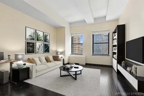 a living room with furniture a flat screen tv and a window