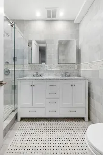a bathroom with a granite countertop sink a toilet and a mirror