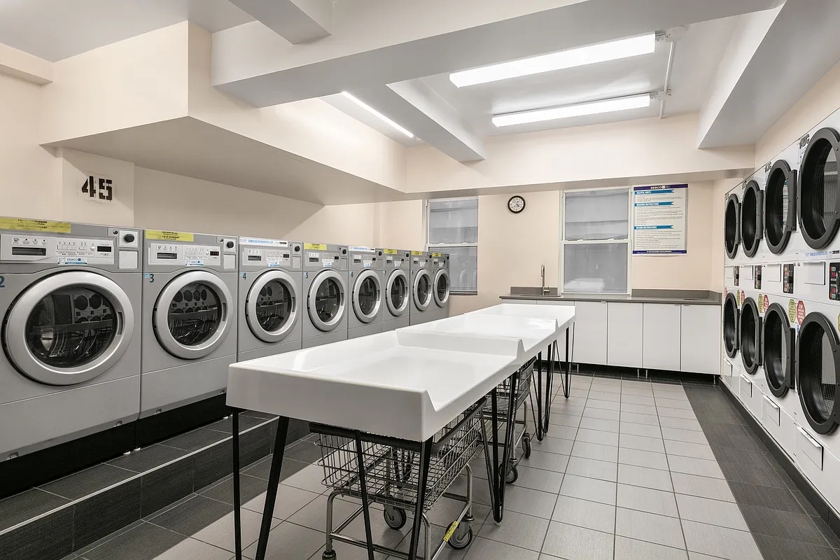 333 East 43rd Street, Unit 910 Manhattan, NY 10017 - Photo 8 of 13 a view of kitchen with washer and dryer