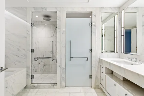 a bathroom with a shower sink vanity and mirror