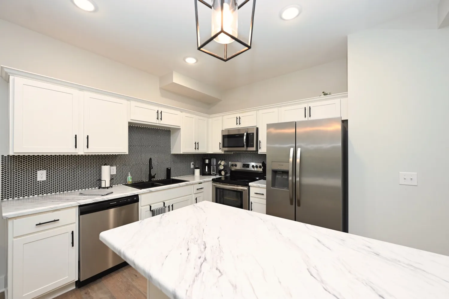 a kitchen with a refrigerator a sink dishwasher a oven with cabinets and wooden floor