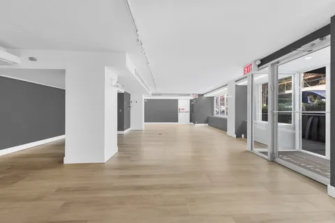 a view of a hallway with wooden floor and entryway
