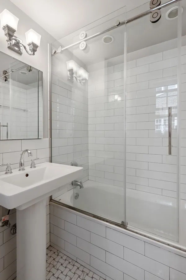 a bathroom with a shower sink vanity and mirror