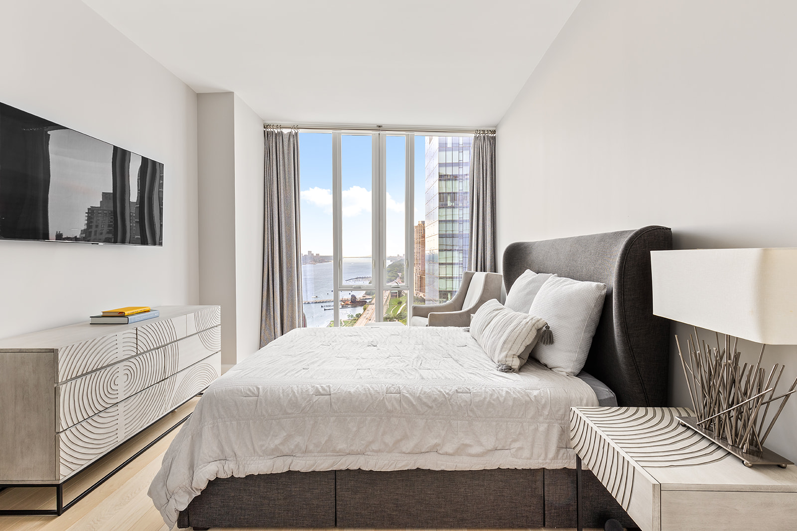 10 Riverside Boulevard, Unit 30B Manhattan, NY 10069 - Photo 7 of 19 a bedroom with a bed and flat screen tv