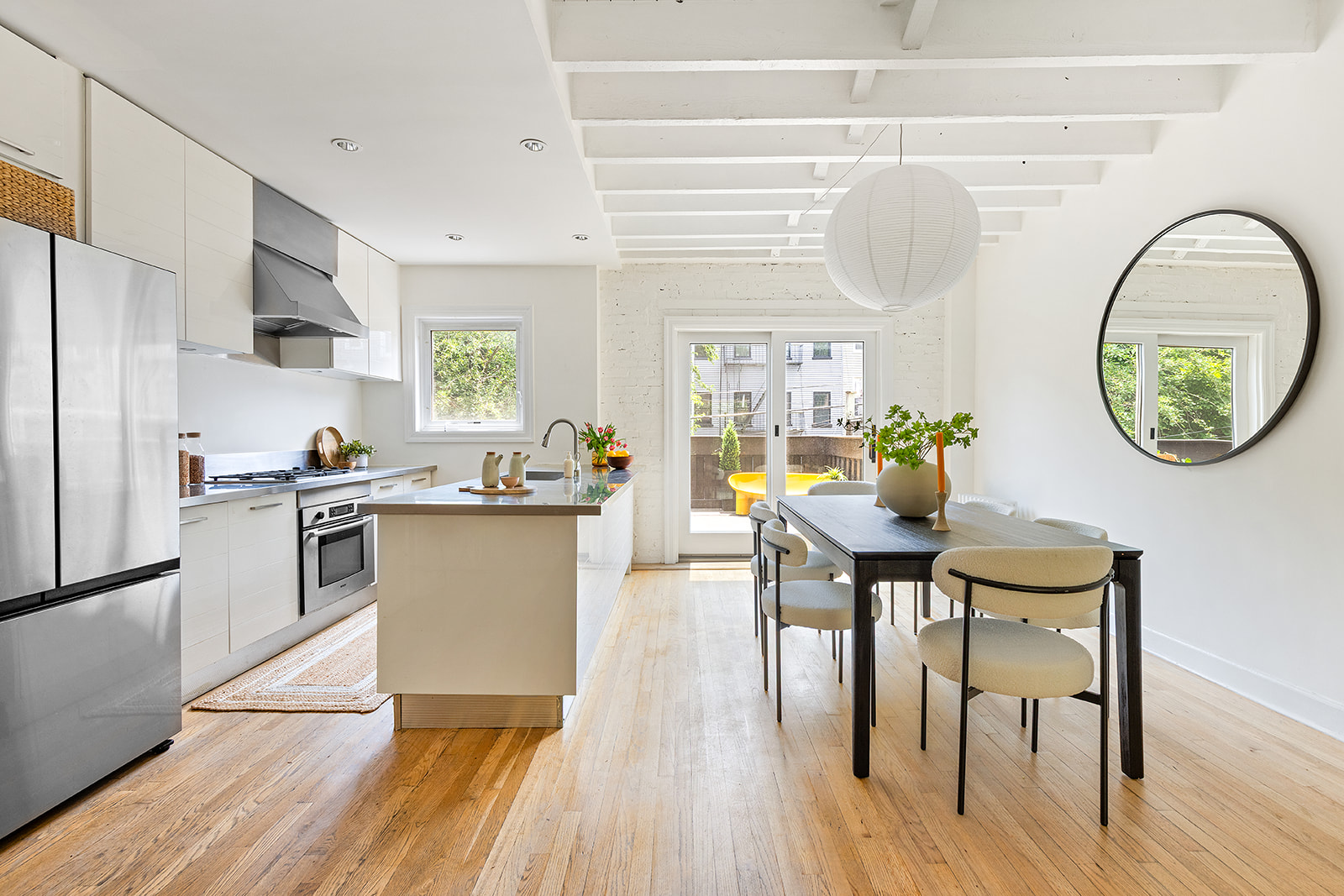 22 Sharon Street Brooklyn, NY 11211 - Photo 2 of 10 a kitchen with a table chairs a sink dishwasher stove and cabinets with wooden floor