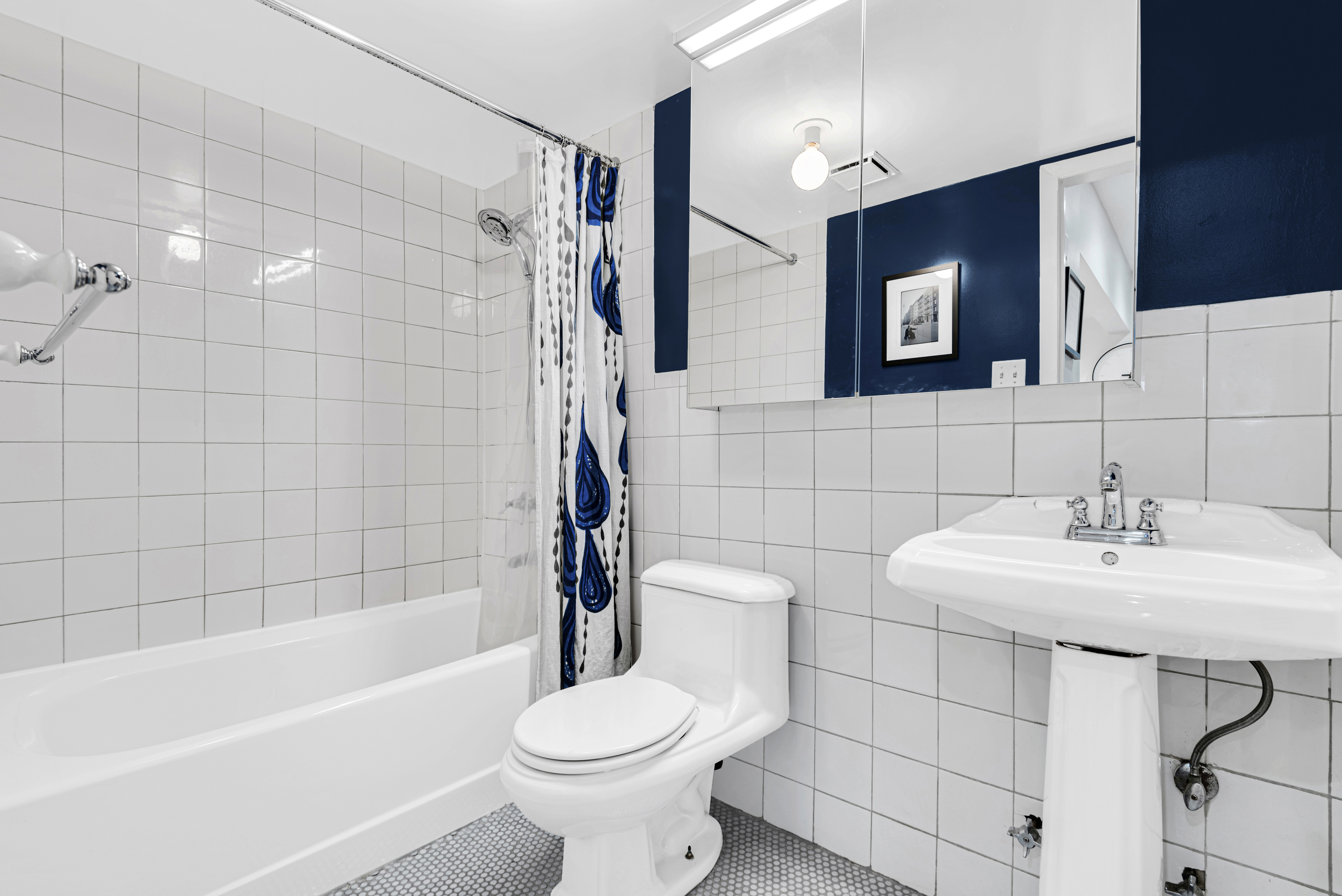 118 Suffolk Street, Unit 3A Manhattan, NY 10002 - Photo 4 of 8 a bathroom with a sink toilet and shower