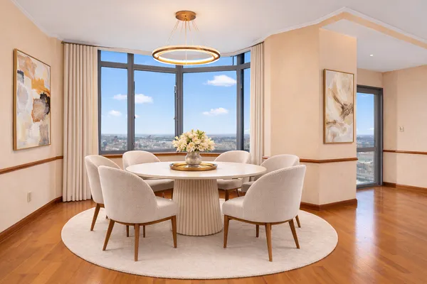 a dining room with furniture a chandelier and wooden floor