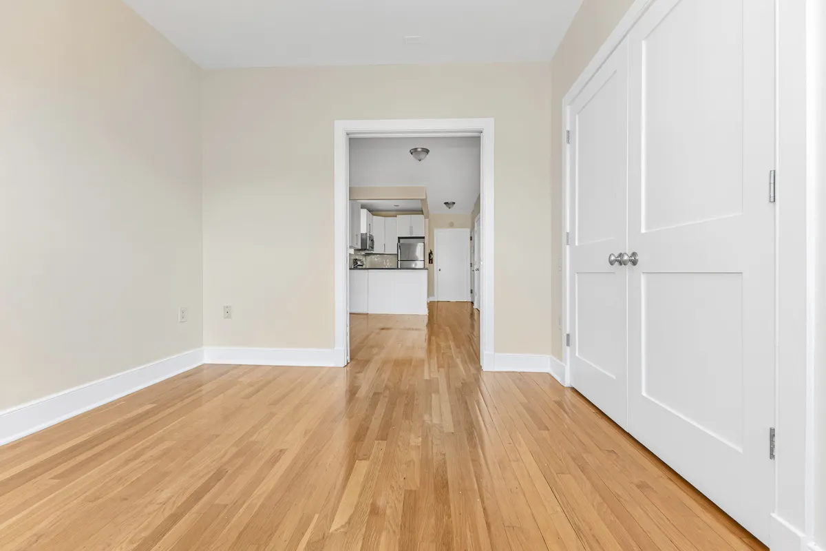a view of a room with wooden floor a ceiling fan and windows