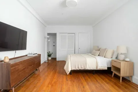 a bedroom with a bed and a flat screen tv