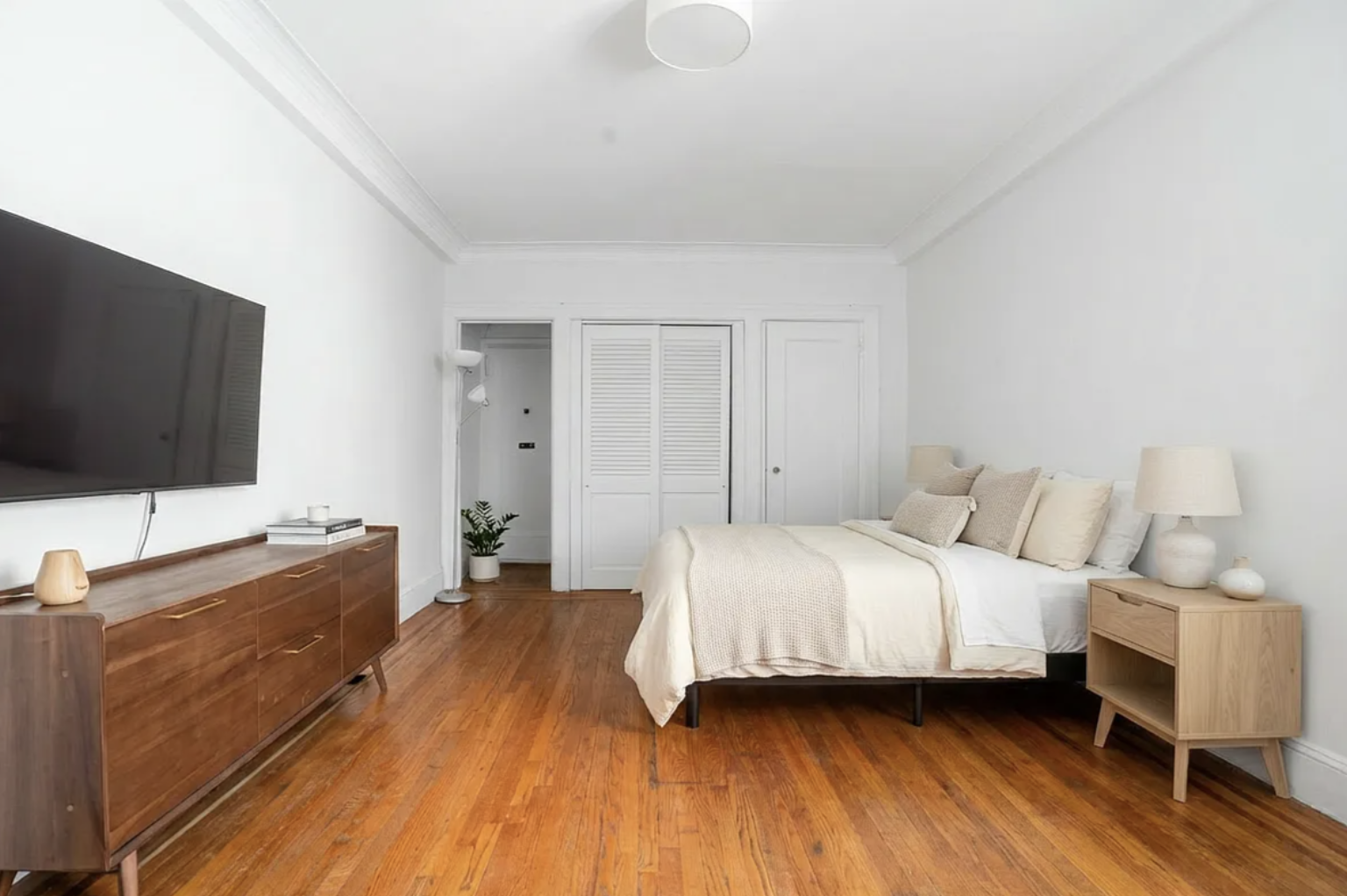 136 East 36th Street, Unit 5E Manhattan, NY 10016 - Photo 2 of 9 a bedroom with a bed and a flat screen tv