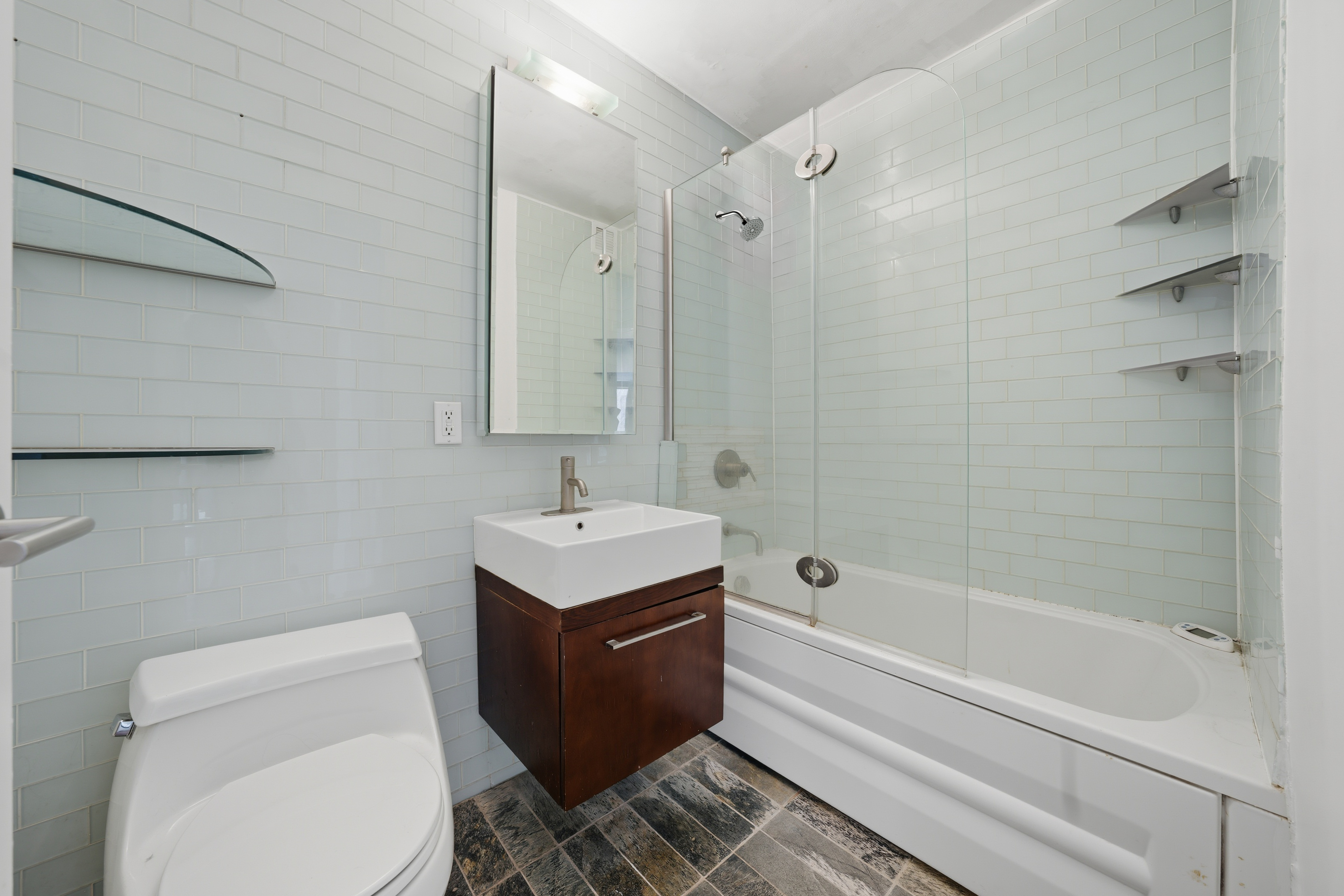 206 East 95th Street, Unit 6B Manhattan, NY 10128 - Photo 18 of 25 a bathroom with a sink a toilet and shower