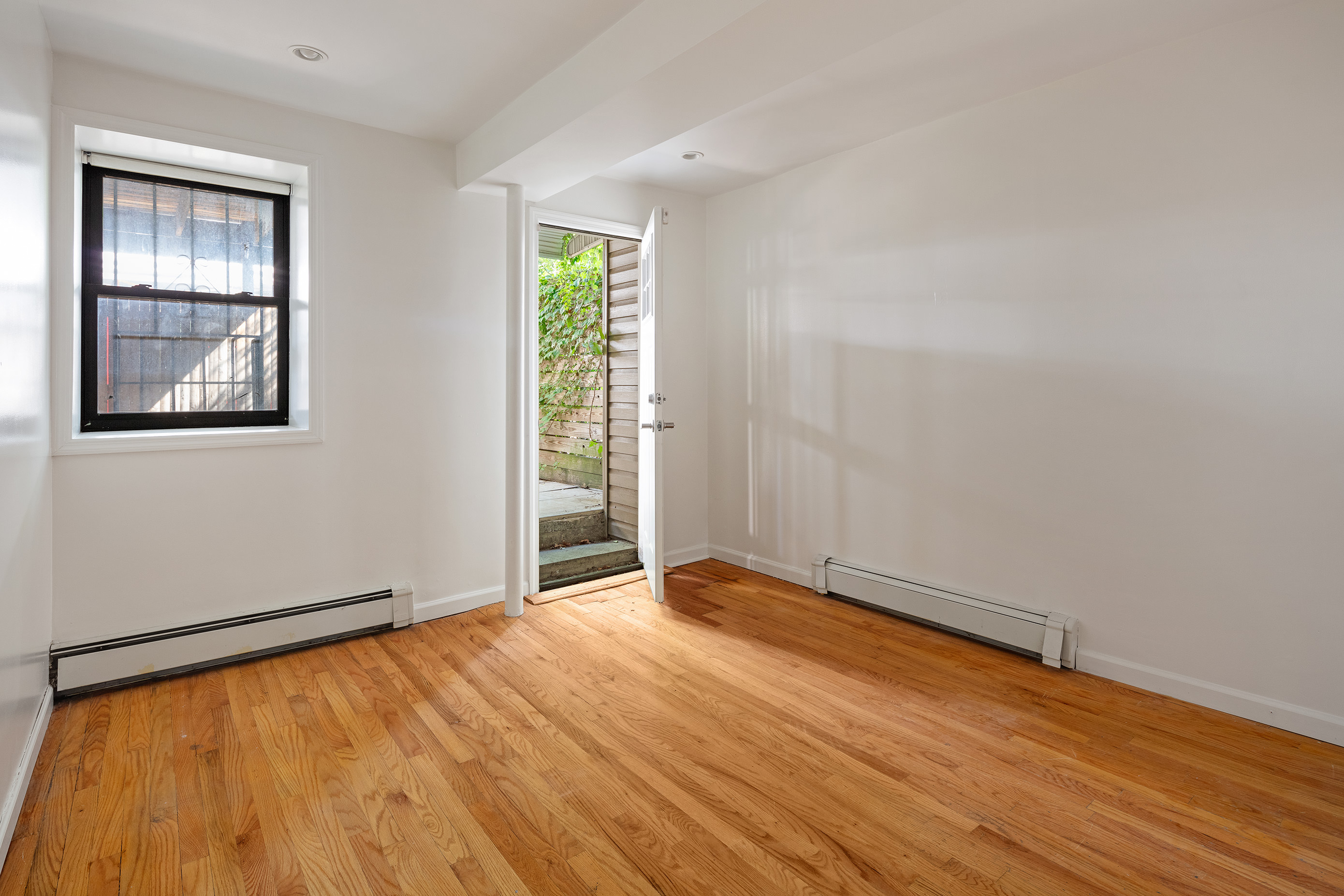14 Covert Street, Unit 1 Brooklyn, NY 11207 - Photo 3 of 9 an empty room with wooden floor and windows