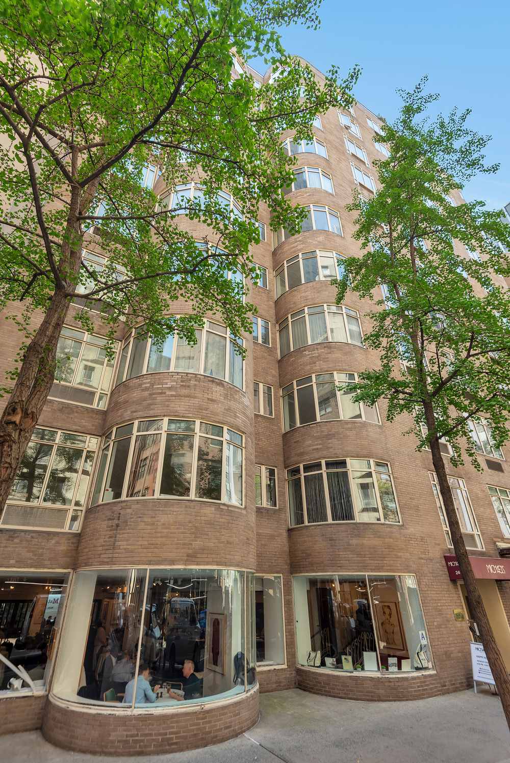 24 West 55th Street, Unit 3D Manhattan, NY 10019 - Photo 8 of 10 a front view of a residential apartment building with a yard