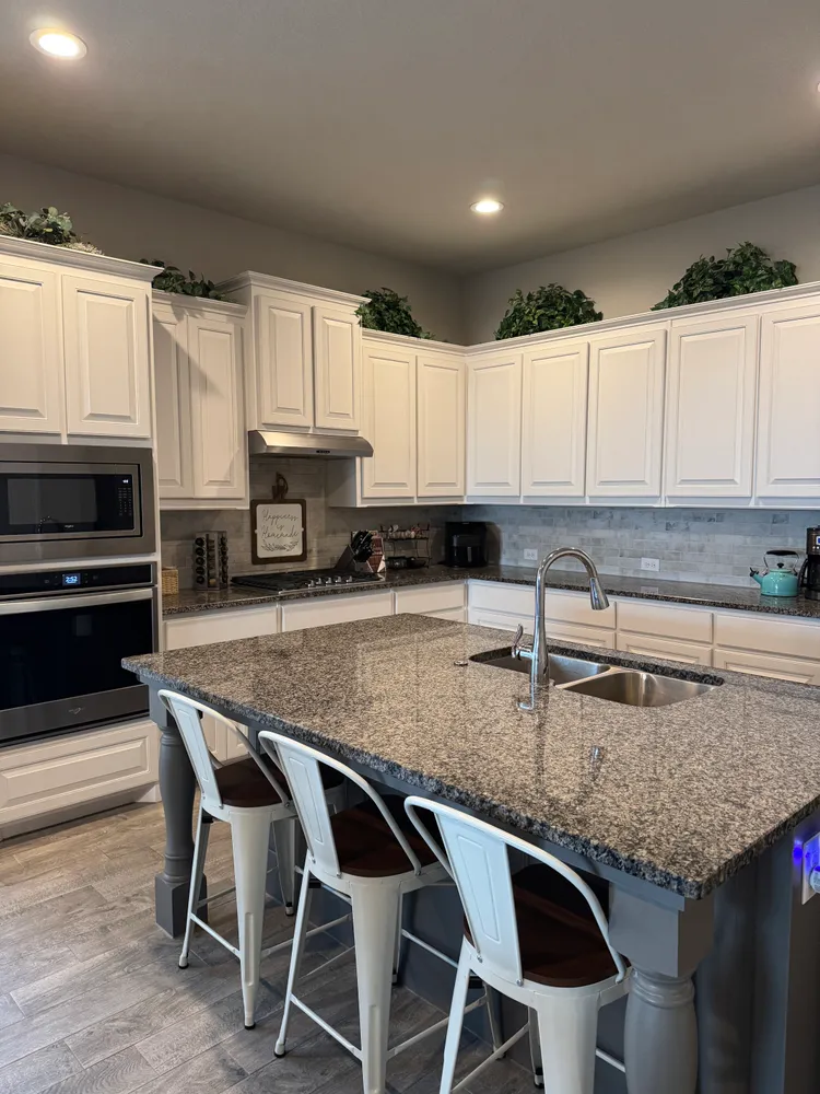 a kitchen with granite countertop a stove a sink and a microwave