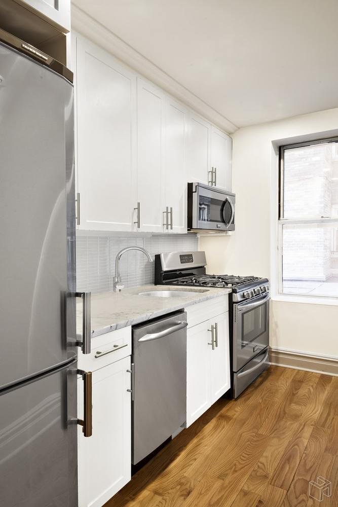 156-08 Riverside Drive West, Unit 1K Manhattan, NY 10032 - Photo 5 of 7 a kitchen with stainless steel appliances granite countertop a stove and a sink