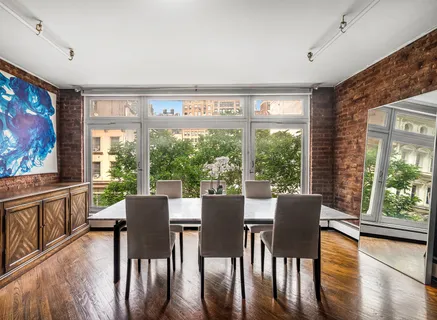 a view of a dining room with furniture large windows and wooden floor