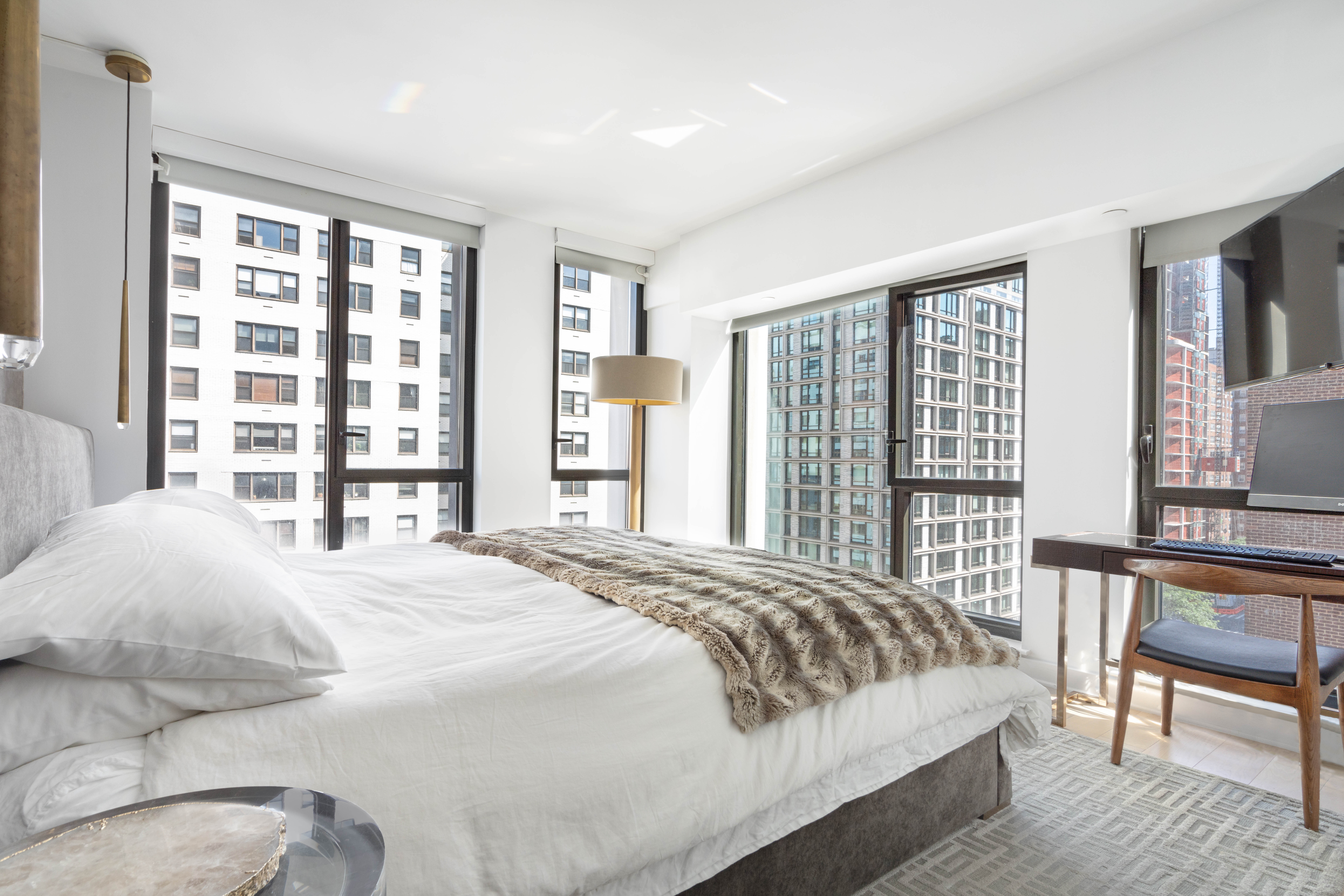 160 East 22nd Street, Unit 9E Manhattan, NY 10010 - Photo 6 of 17 a bedroom with a large bed and a large window