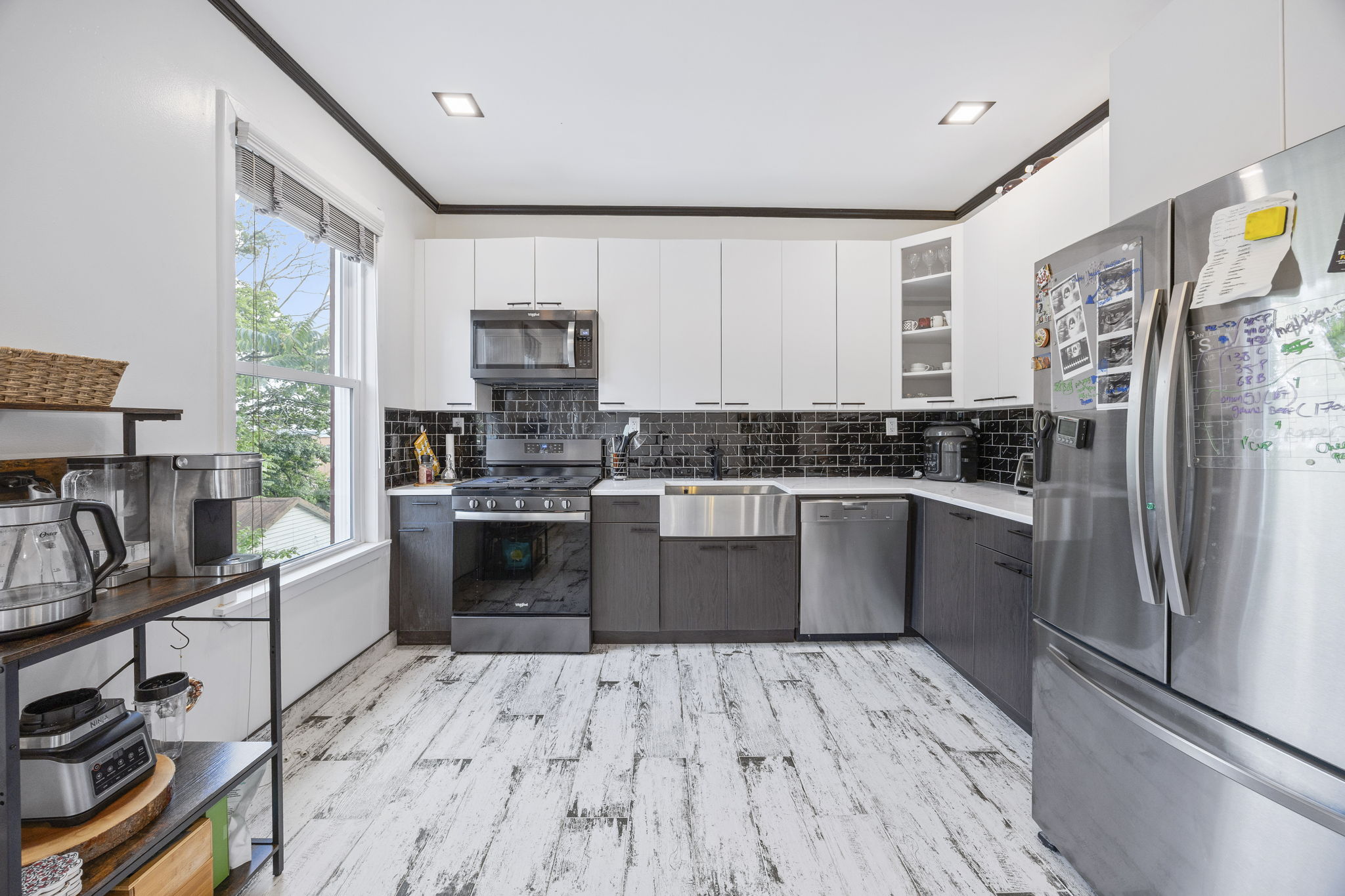 25-69 46th Street, Unit 2 Queens, NY 11103 - Photo 2 of 13 a kitchen with a refrigerator wooden floor a stove a sink and a window