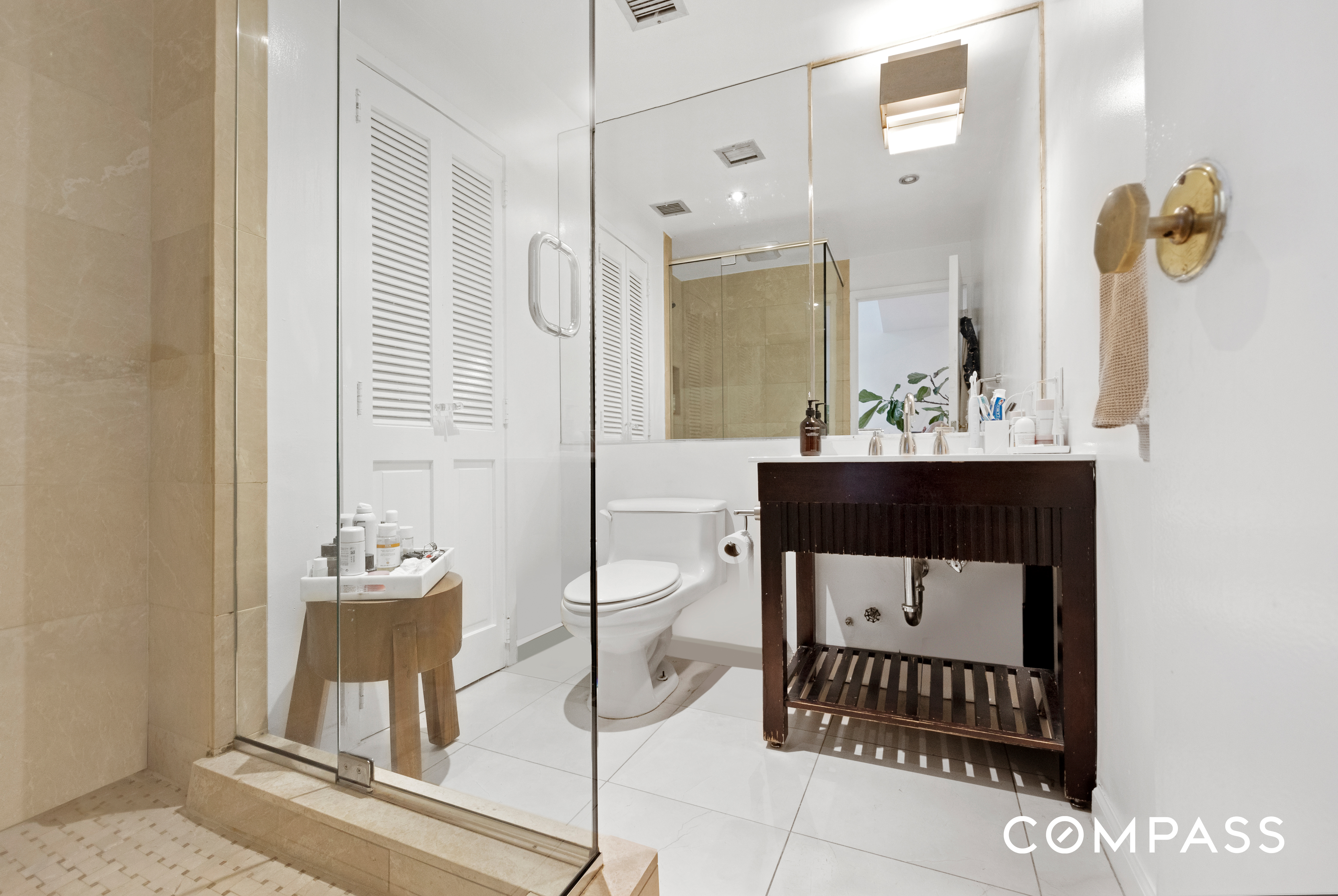 152 East 74th Street, Unit 2 Manhattan, NY 10021 - Photo 11 of 16 a bathroom with a sink a toilet and mirror