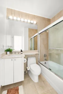a bathroom with a sink a toilet a mirror and bathtub