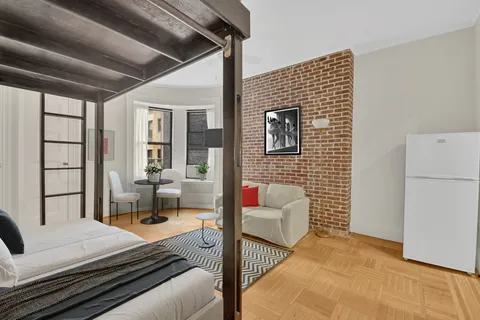 a bedroom with furniture and a large window