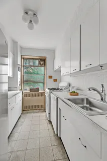 a kitchen with a sink window and cabinets