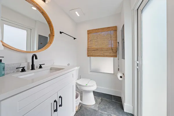 a bathroom with a sink a toilet and a mirror