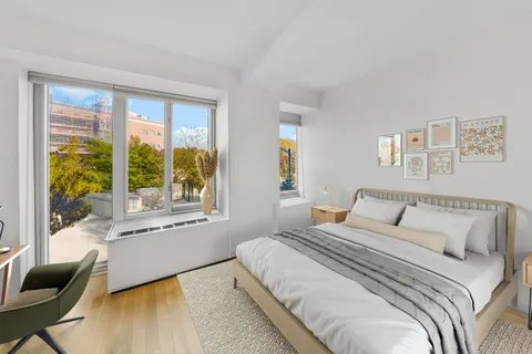 a bedroom with a large bed and a large window