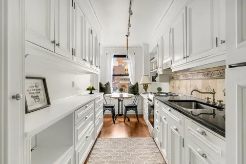 a kitchen with stainless steel appliances granite countertop a sink a stove a refrigerator a counter space and cabinets