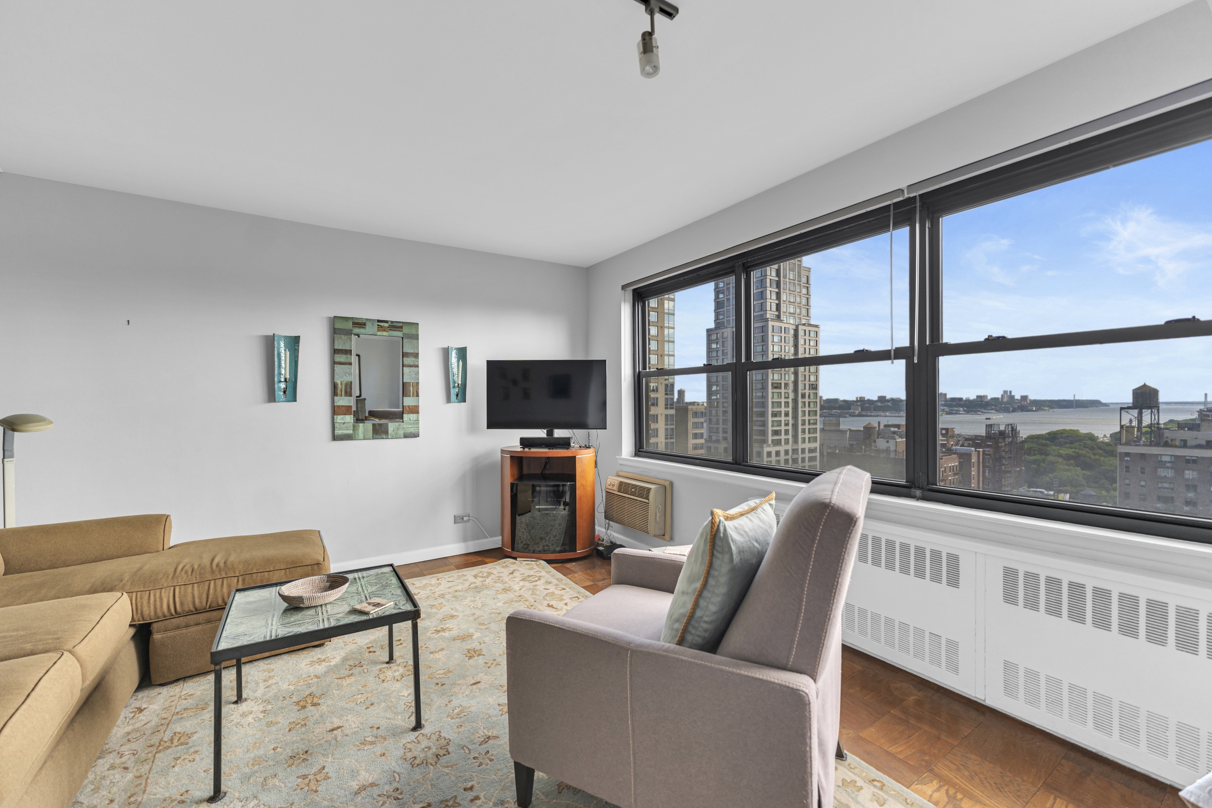 205 West End Avenue, Unit 23E Manhattan, NY 10023 - Photo 7 of 15 a living room with furniture tv and a large window