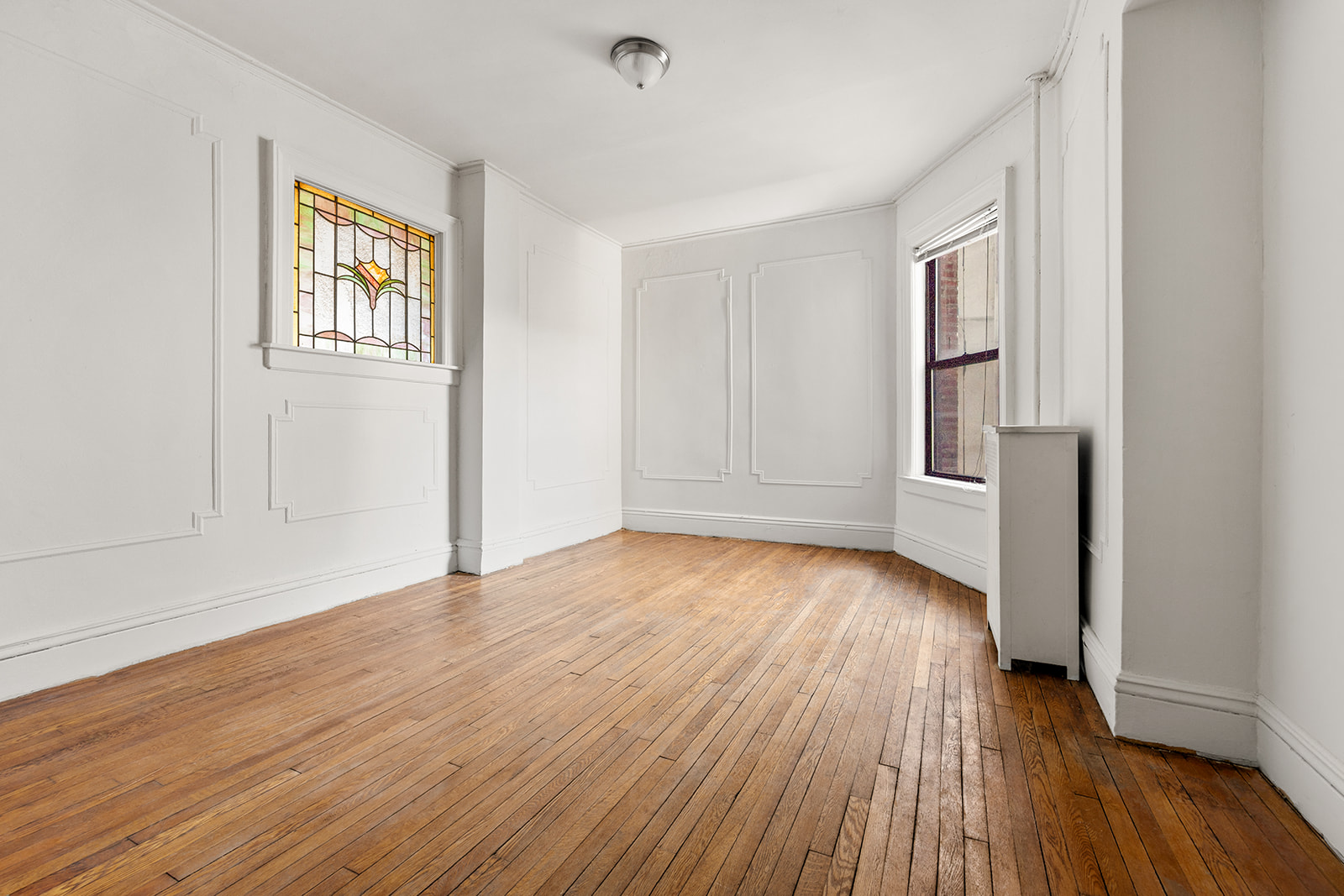 310 Windsor Place, Unit 32 Brooklyn, NY 11218 - Photo 8 of 19 an empty room with wooden floor and windows