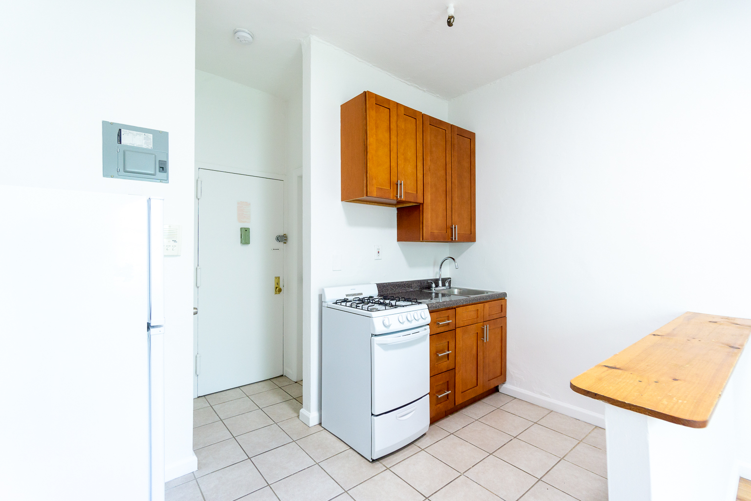 320 West 20th Street, Unit 15 Manhattan, NY 10011 - Photo 4 of 8 a kitchen with a stove top oven and cabinets