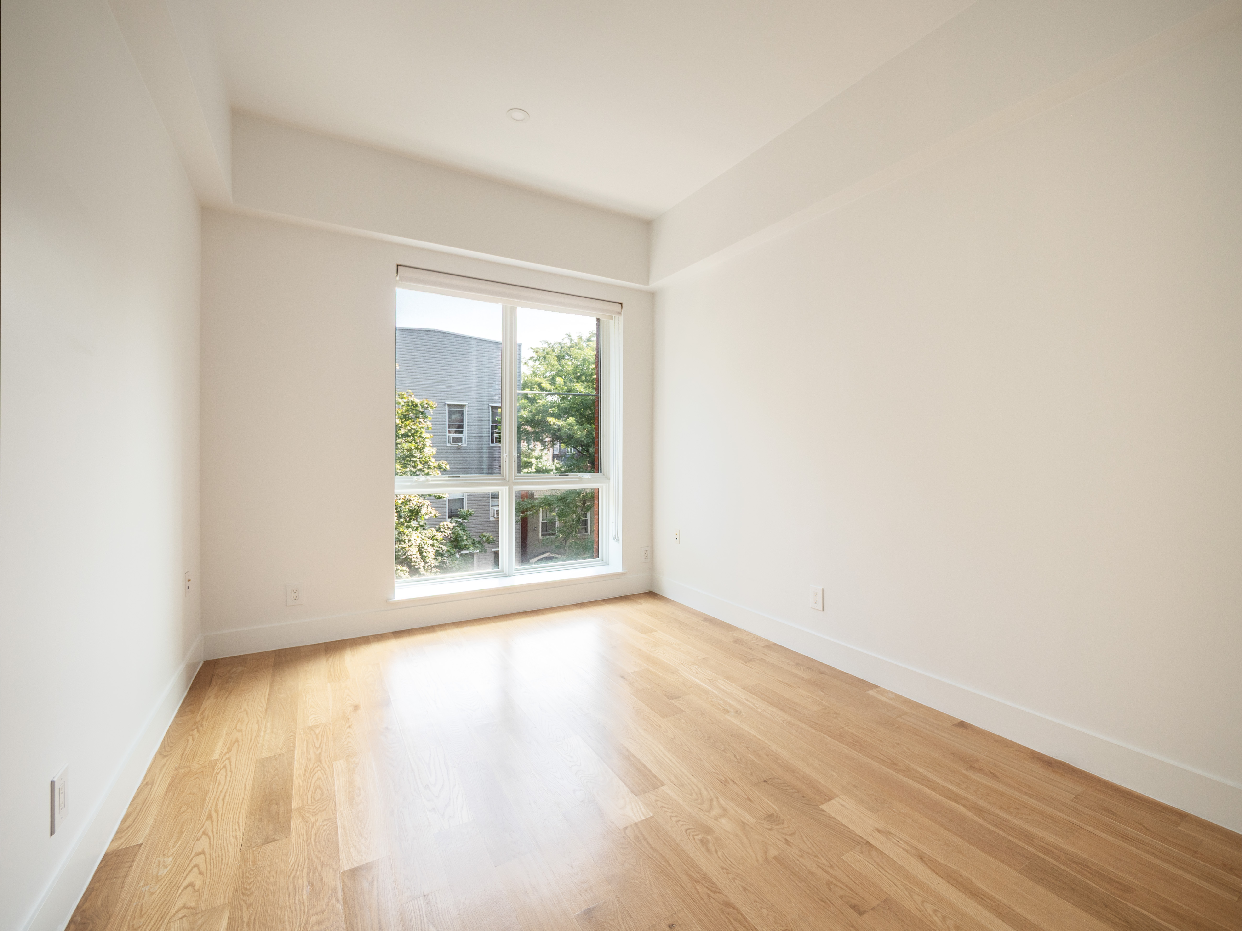 21 Powers Street, Unit 3A Brooklyn, NY 11211 - Photo 12 of 14 a view of an empty room with wooden floor and a window