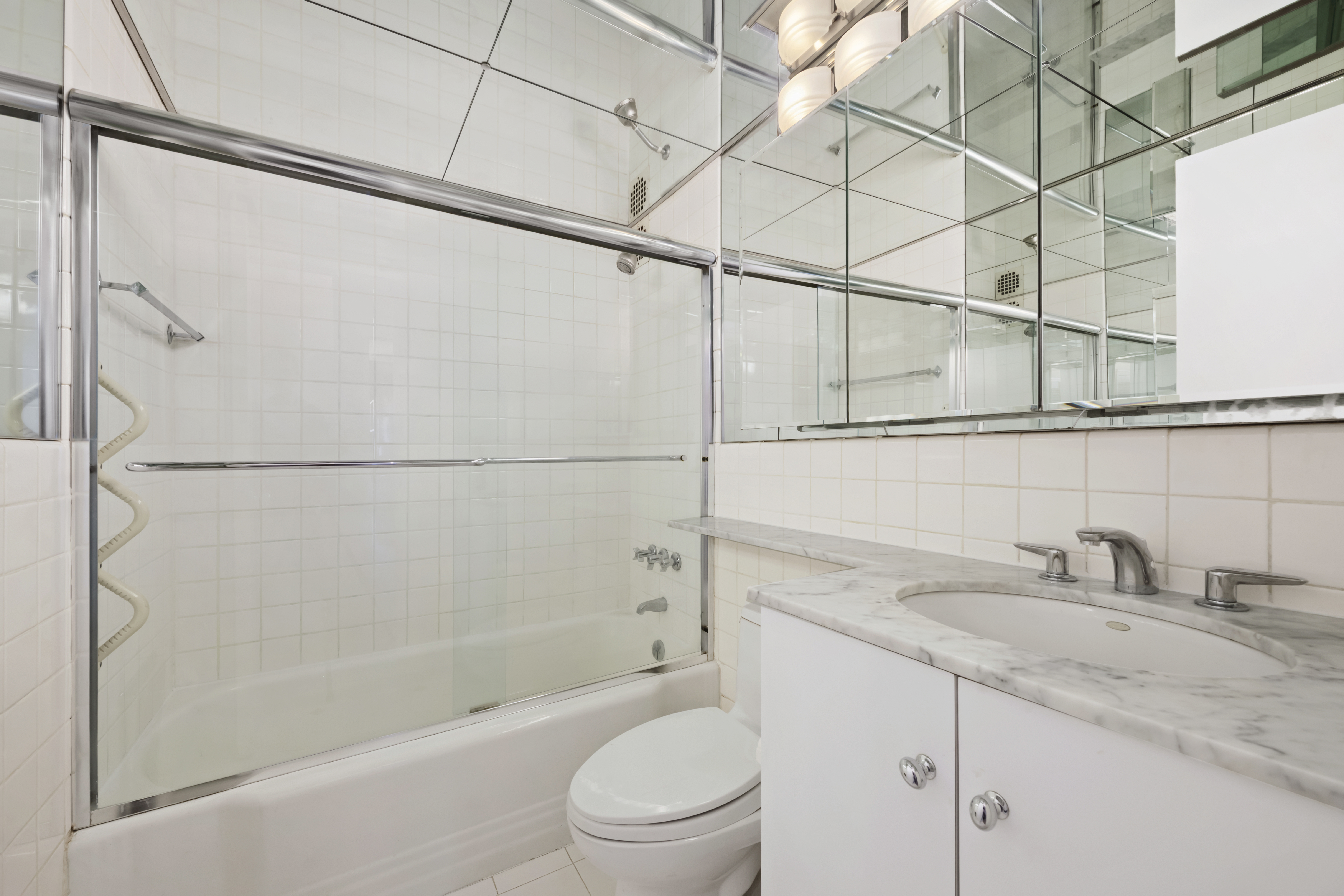25 Sutton Place South, Unit 16B Manhattan, NY 10022 - Photo 11 of 16 a bathroom with a granite countertop sink toilet and shower