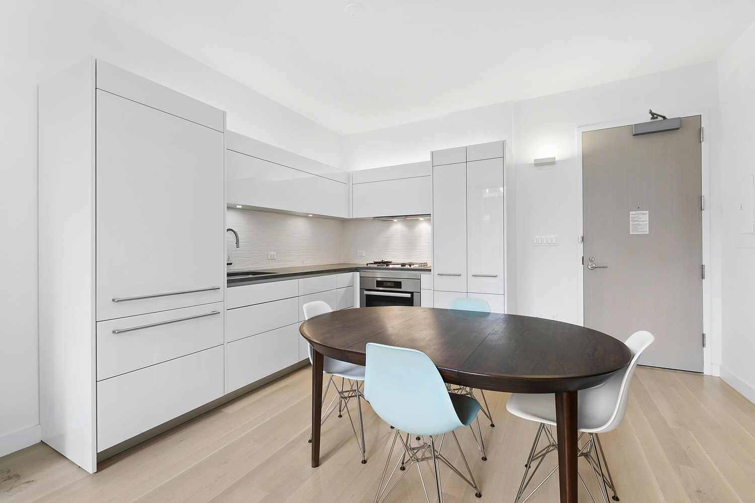 241 5th Avenue, Unit 13C Manhattan, NY 10016 - Photo 2 of 9 a kitchen with a table chairs and a refrigerator