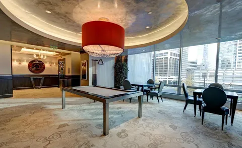 a dining room with furniture and a floor to ceiling window