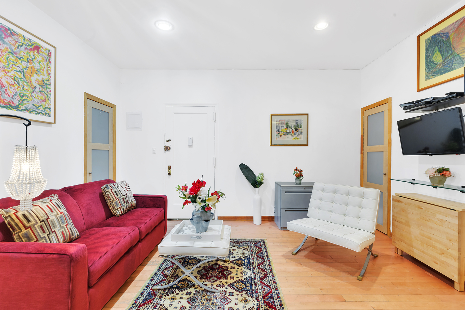 57 West 58th Street, Unit 3D Manhattan, NY 10019 - Photo 2 of 7 a living room with furniture and a flat screen tv
