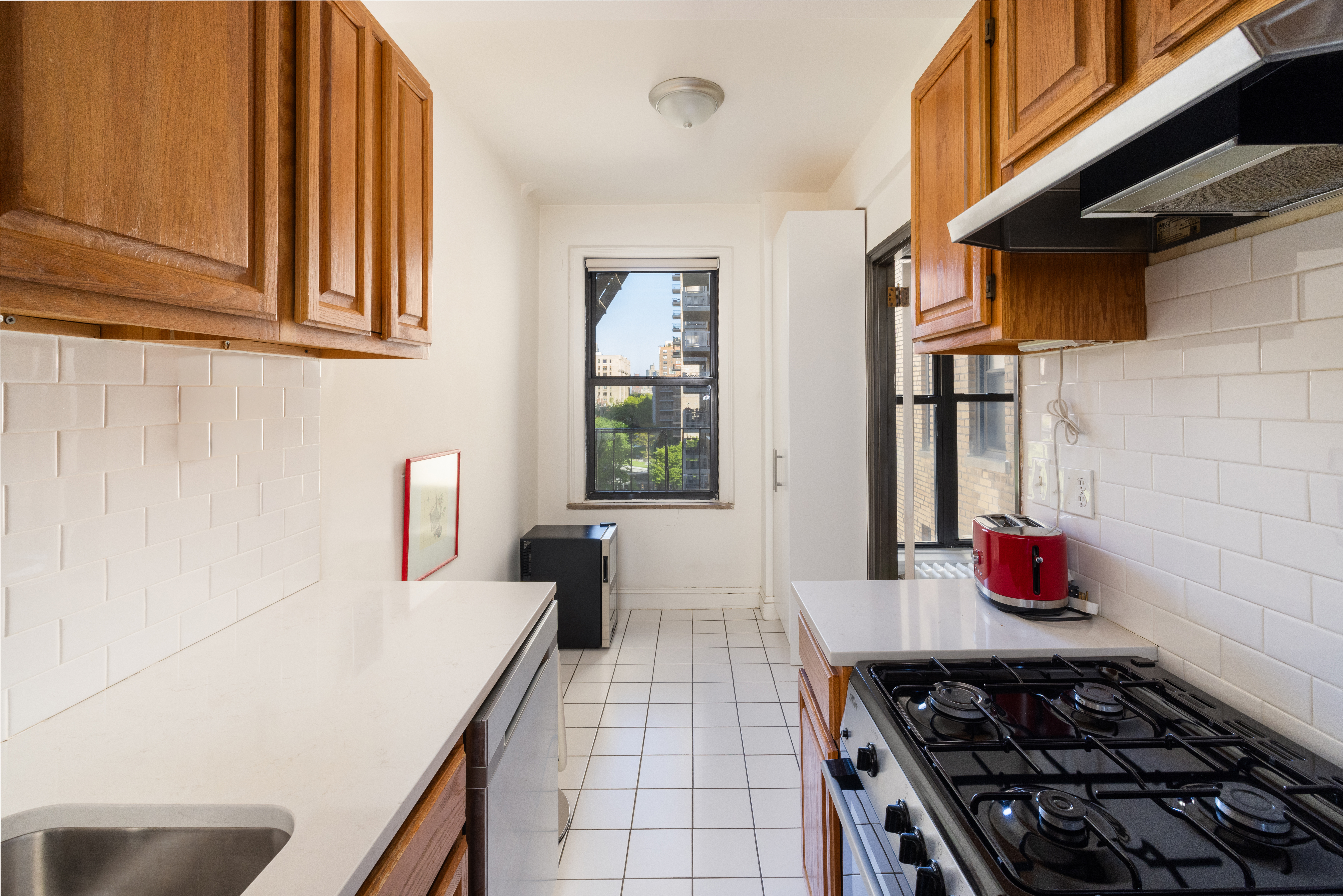 124 West 93rd Street, Unit 6E Manhattan, NY 10025 - Photo 4 of 9 a kitchen with stainless steel appliances granite countertop a stove and a sink