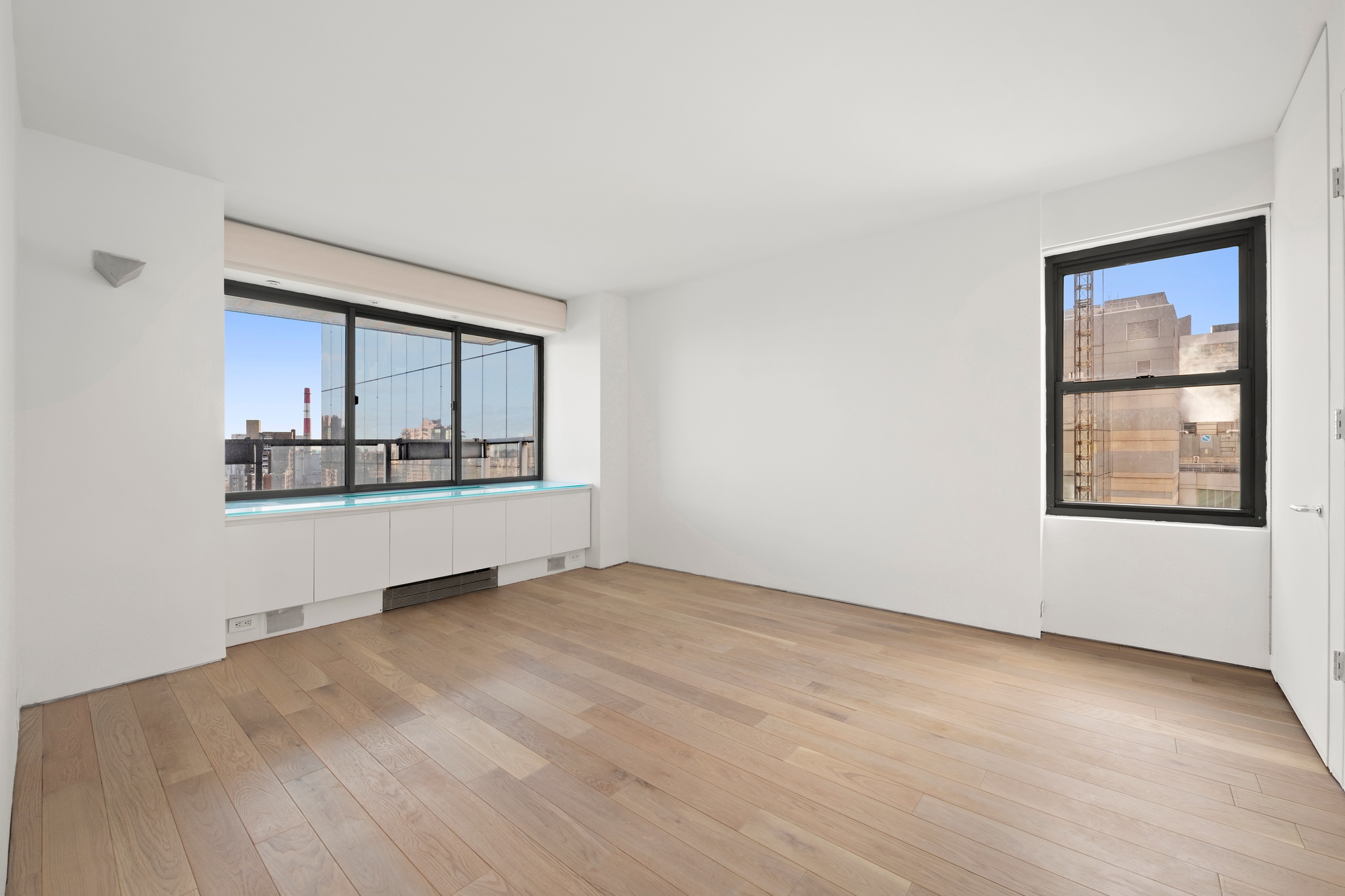 530 East 72nd Street, Unit 14E Manhattan, NY 10021 - Photo 16 of 19 an empty room with wooden floor and windows