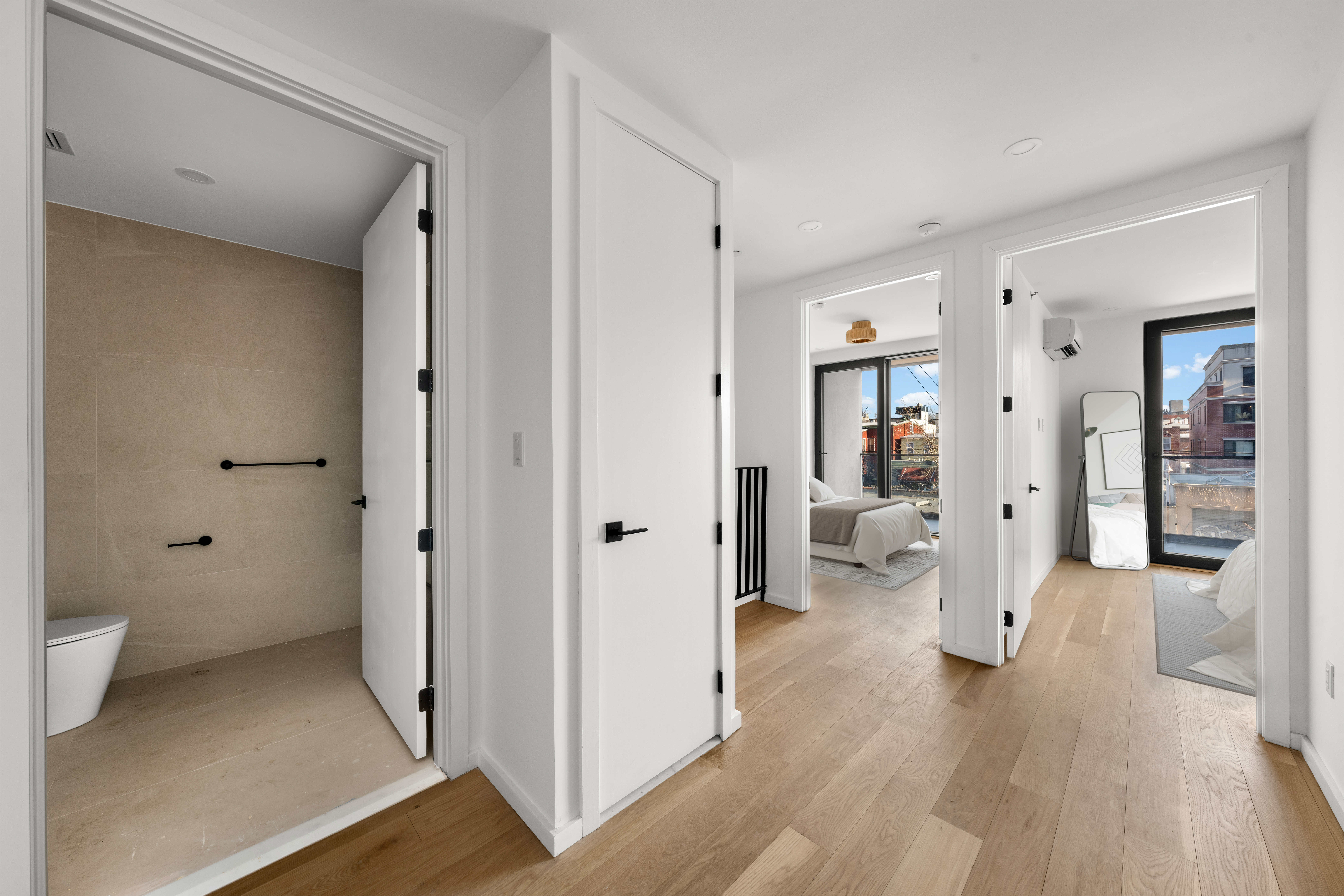 14-35 Broadway, Unit 1A Queens, NY 11106 - Photo 17 of 20 a view of a bedroom with a hardwood floor and a bathroom