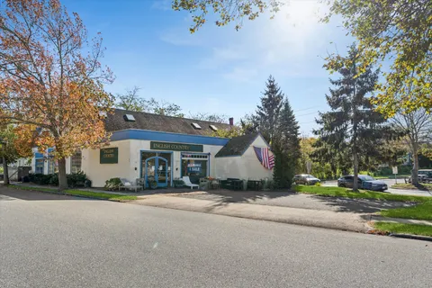 a view of a house with a yard and large trees