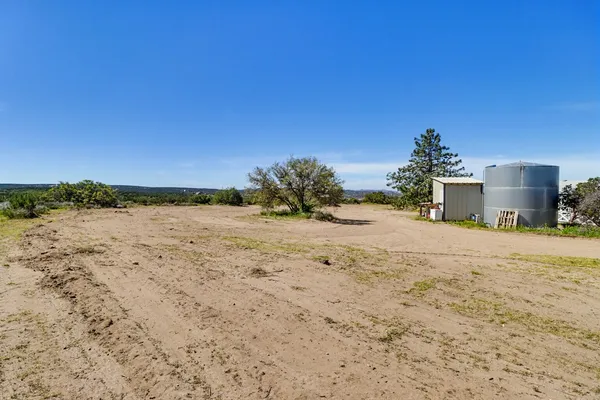 a view of dirt yard with a large tree