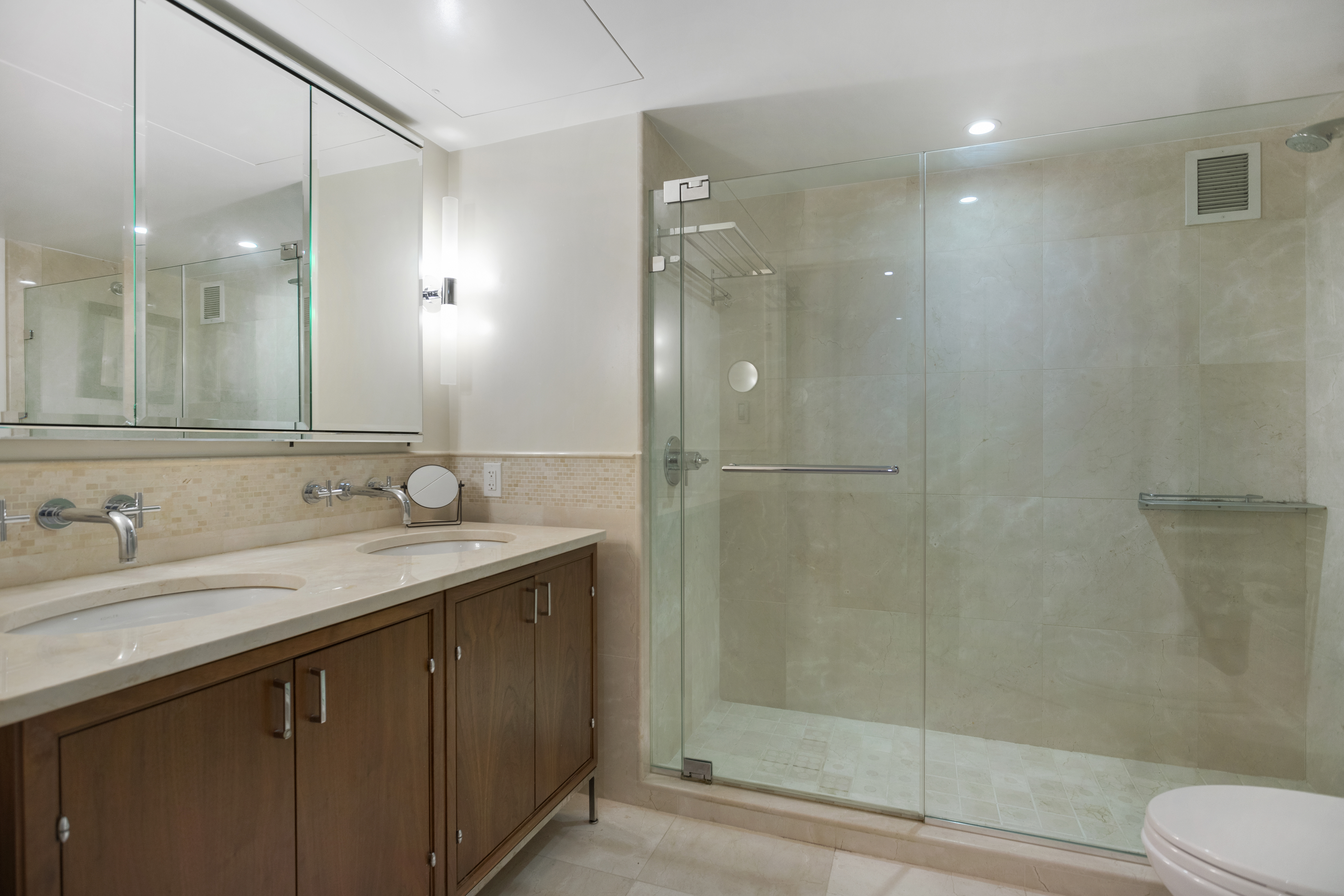 200 East 66th Street, Unit B205 Manhattan, NY 10065 - Photo 10 of 14 a bathroom with a sink shower and a mirror