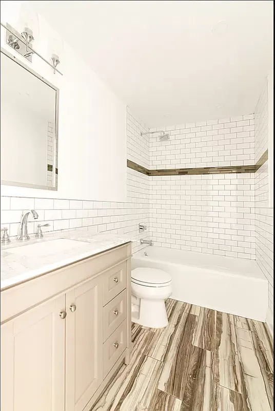 894 Greene Avenue Brooklyn, NY 11221 - Photo 8 of 11 a bathroom with a sink a toilet and shower